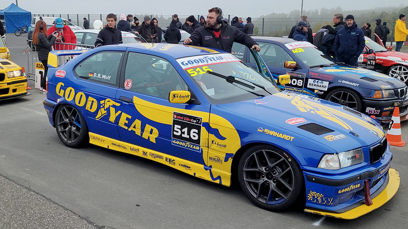 20-jähriger Rookie Rennfahrer Denis Robin Wolf auf dem Nürburgring an seinem vierten Rennwochenende - beim Vorstadt in seinem BMW 318ti Cup Rennwagen wartend, Car-Chief an der Seite