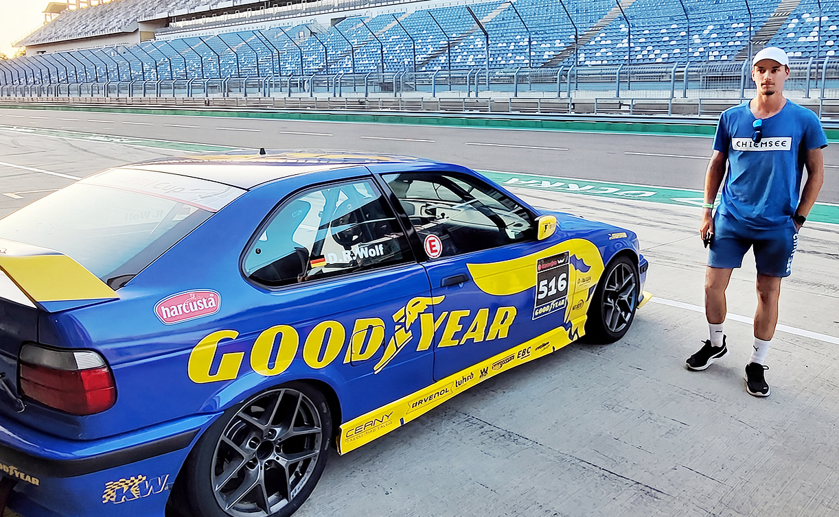 Denis entspannt neben seinem Rennauto stehend