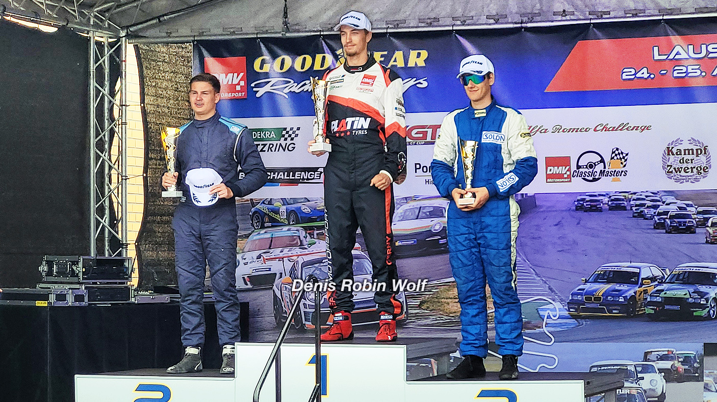 20-jähriger Rookie Rennfahrer Denis Robin Wolf auf dem Lausitzring an seinem dritten Rennwochenende -  als Gesamtsieger auf dem Podium mit einem Pokal in der Hand 