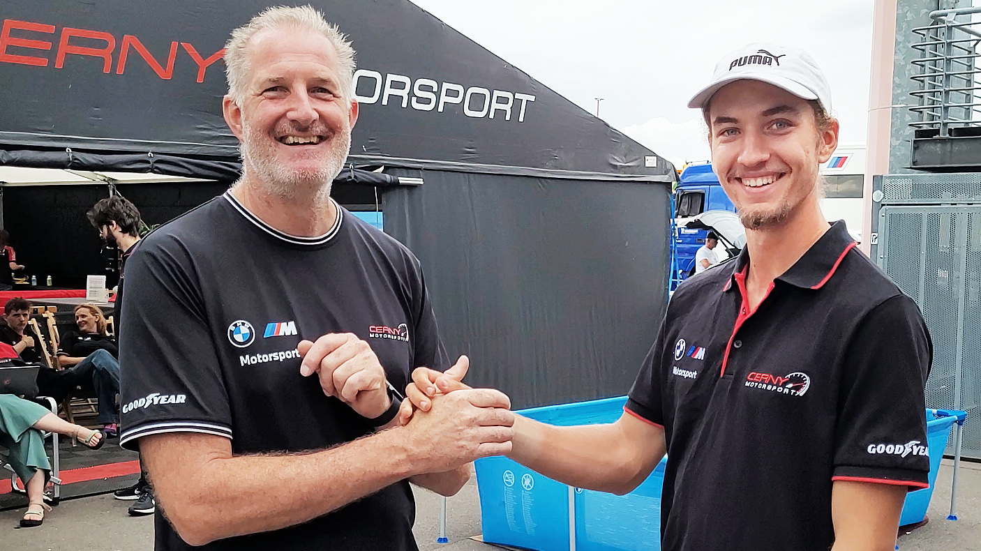 Bild mit 20-jährigem Rennfahrer Denis Robin Wolf auf dem Lausitzring während seines dritten Rennwochenendes als Rookie in seiner Debütsaison, nach dem Rennsieg mit Teamchef Henry Cerny zusammen stehend