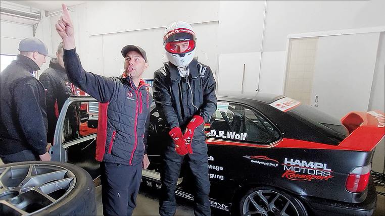 20-jährigem Rennfahrer Denis Robin W20-jährigem Rookie Rennfahrer Denis Robin Wolf in Assen nach dem Rennen neben Teamchef und seinem BMW 318ti Cup Rennwagens stehend