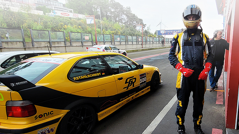 20-jähriger Rennfahrer Denis Robin Wolf in Zolder, nach seiner Testfahrt neben einem BMW 318ti Cup Rennwagen stehend