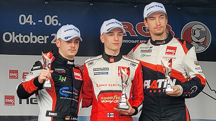 20-jähriger Rookie Rennfahrer Denis Robin Wolf auf dem Nürburgring an seinem vierten Rennwochenende - auf dem Podium mit einem Pokal in der Hand stehend - Nahaufnahme mit Podiumkollegen